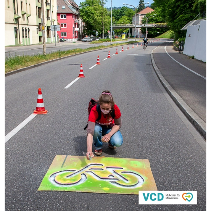 Vertreterin des Verkehrsclub Deutschland sprüht Fahrrad auf Straße in Freiburg Vertreterin des Verkehrsclub Deutschland sprüht Fahrrad auf Straße in Freiburg
